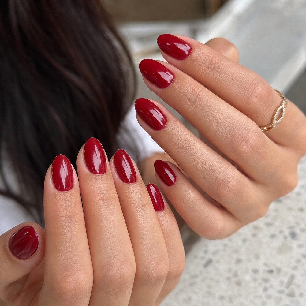 Glossy cherry red almond gel manicure with a glazed finish
